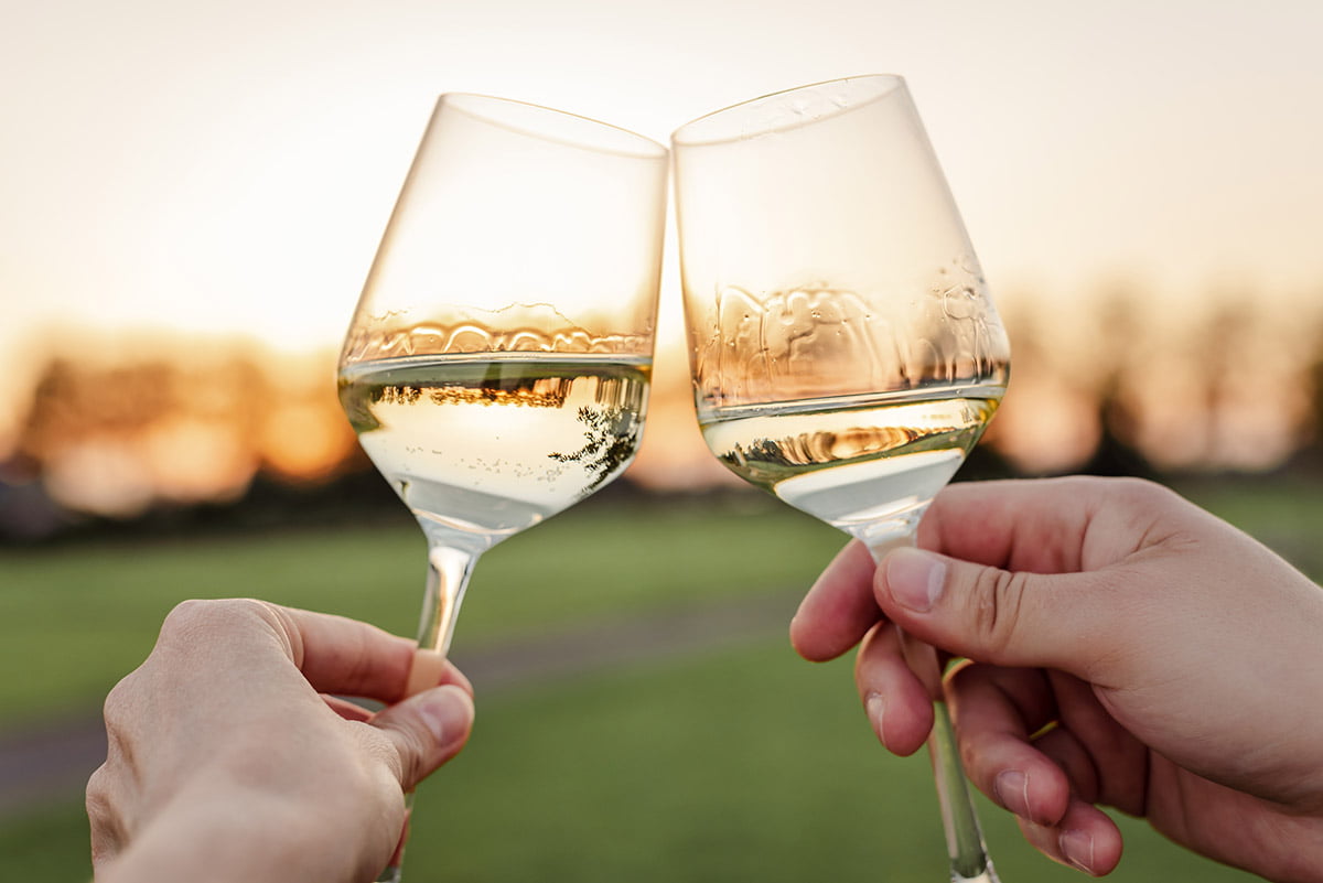 2 glasses cheers in the sunset at Paserene Wine Estate